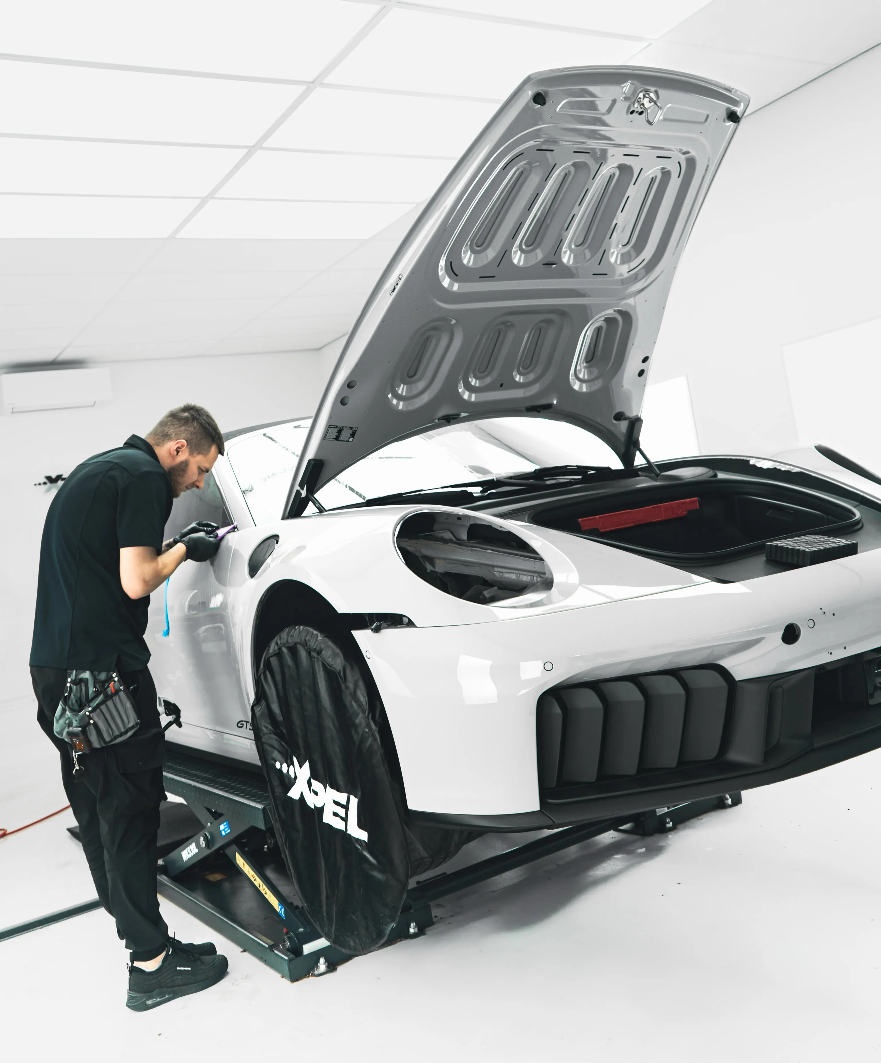 Specialist van P&P Car Care brengt paint protection film aan op het voorscherm van de Porsche 911 Targa 4 GTS