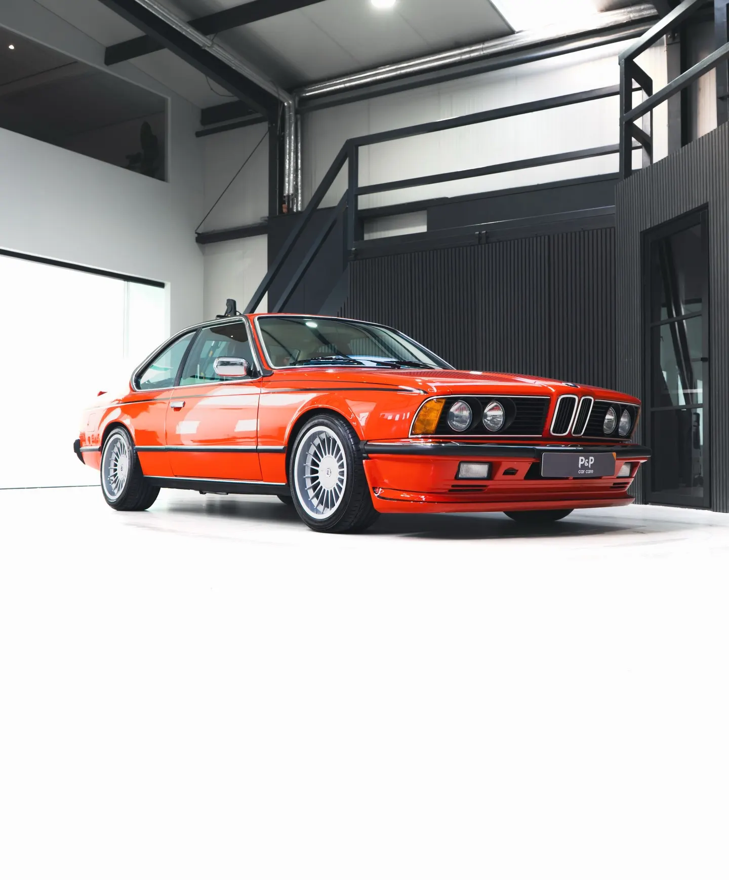 Rode BMW 635 CSi in de studio van P&P Car Care, driekwart vooraanzicht