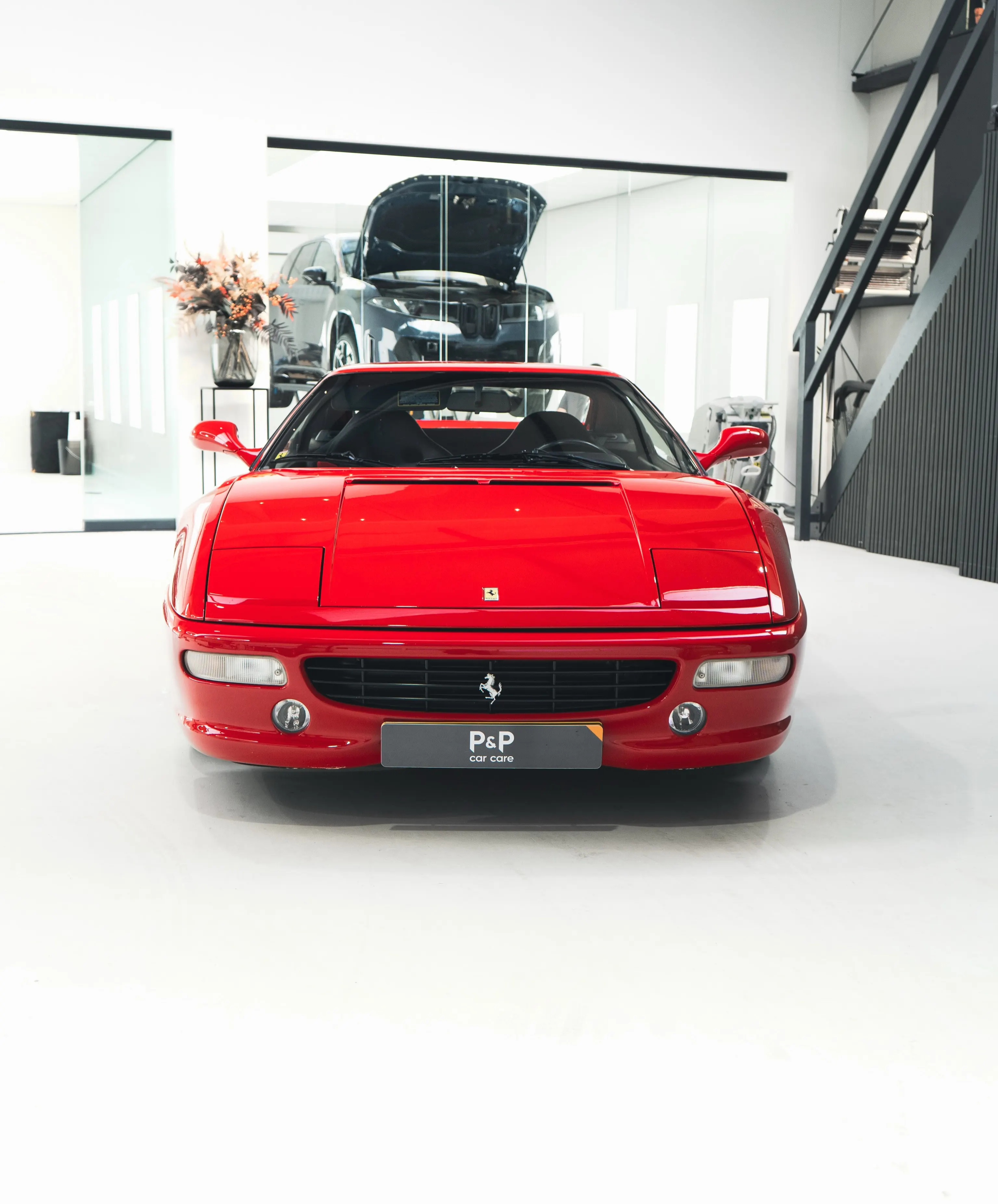Rode Ferrari F355 GTS in vooraanzicht in de showroom