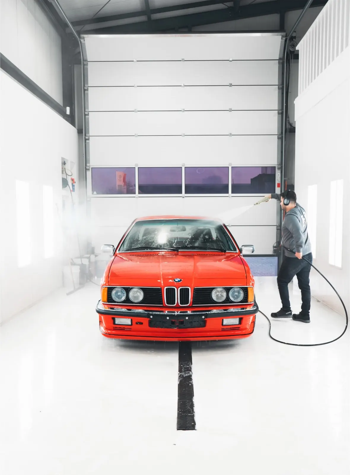 Specialist van P&P Car Care wast de BMW 635 CSi in de wasbox