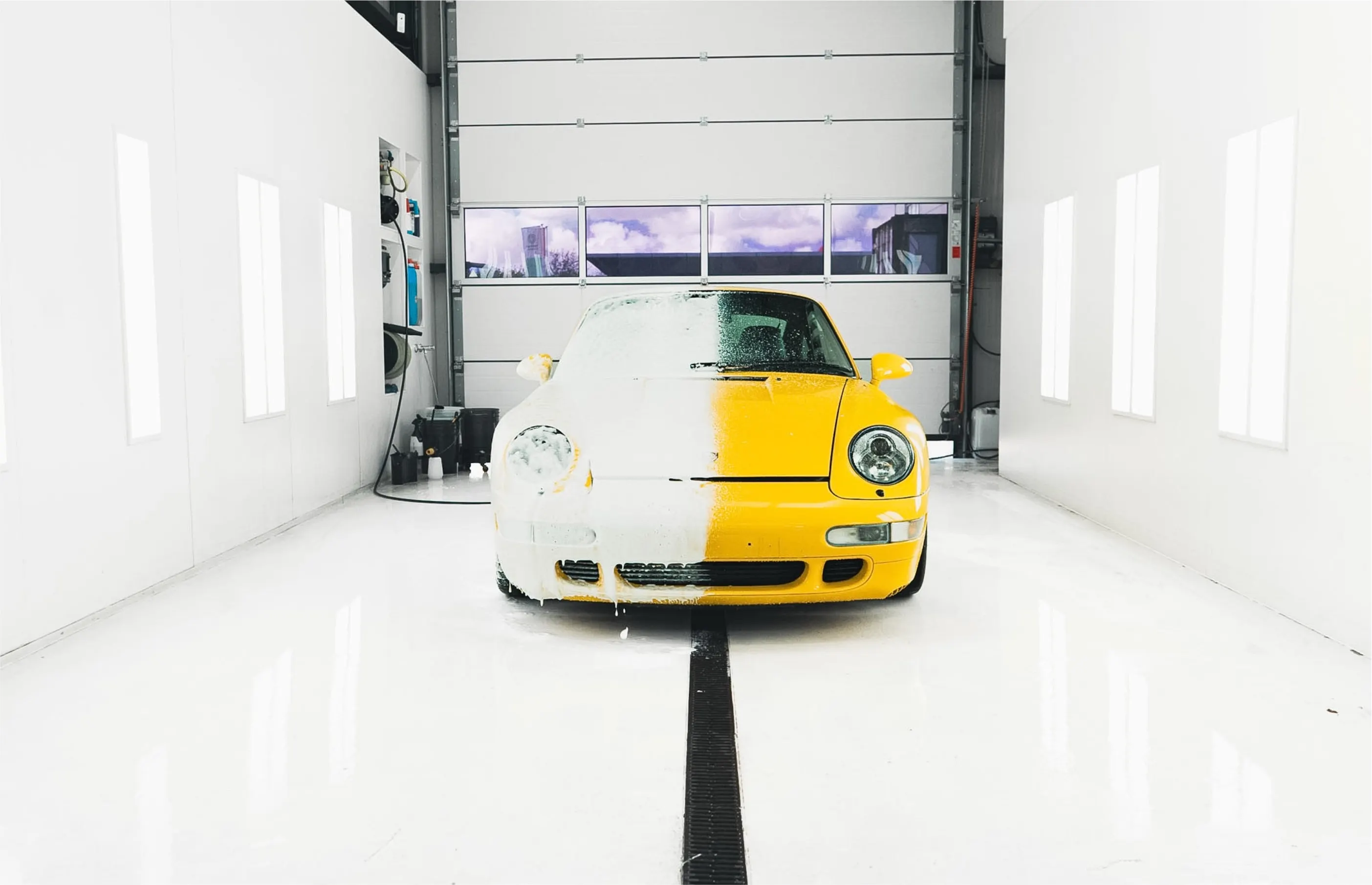 De Porsche 993 Turbo half onder het schuim in de wasruimte van P&P Car Care