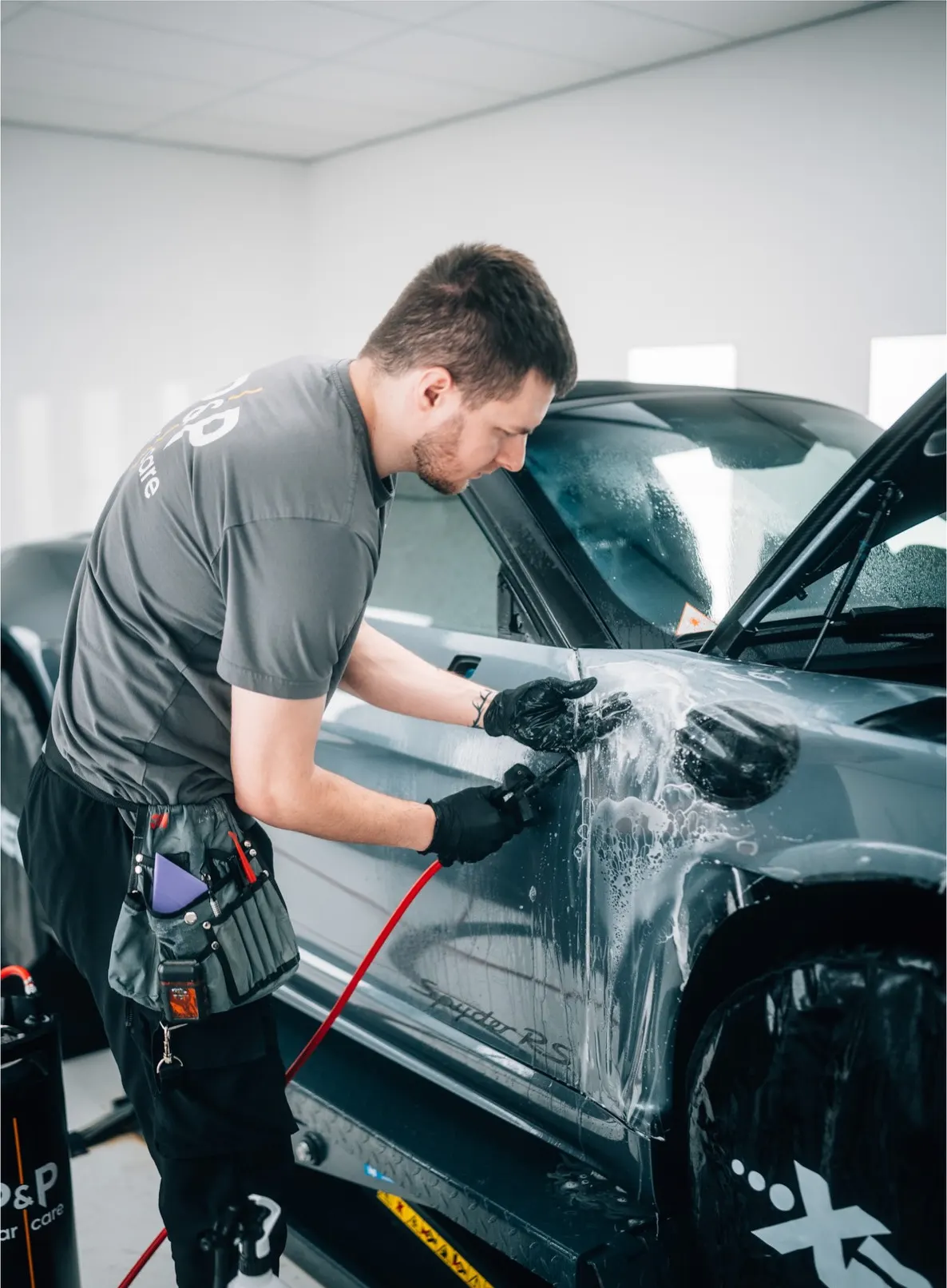 Specialist van P&P Car Care wast de Porsche 718 Spyder RS met foam voor de installatie
