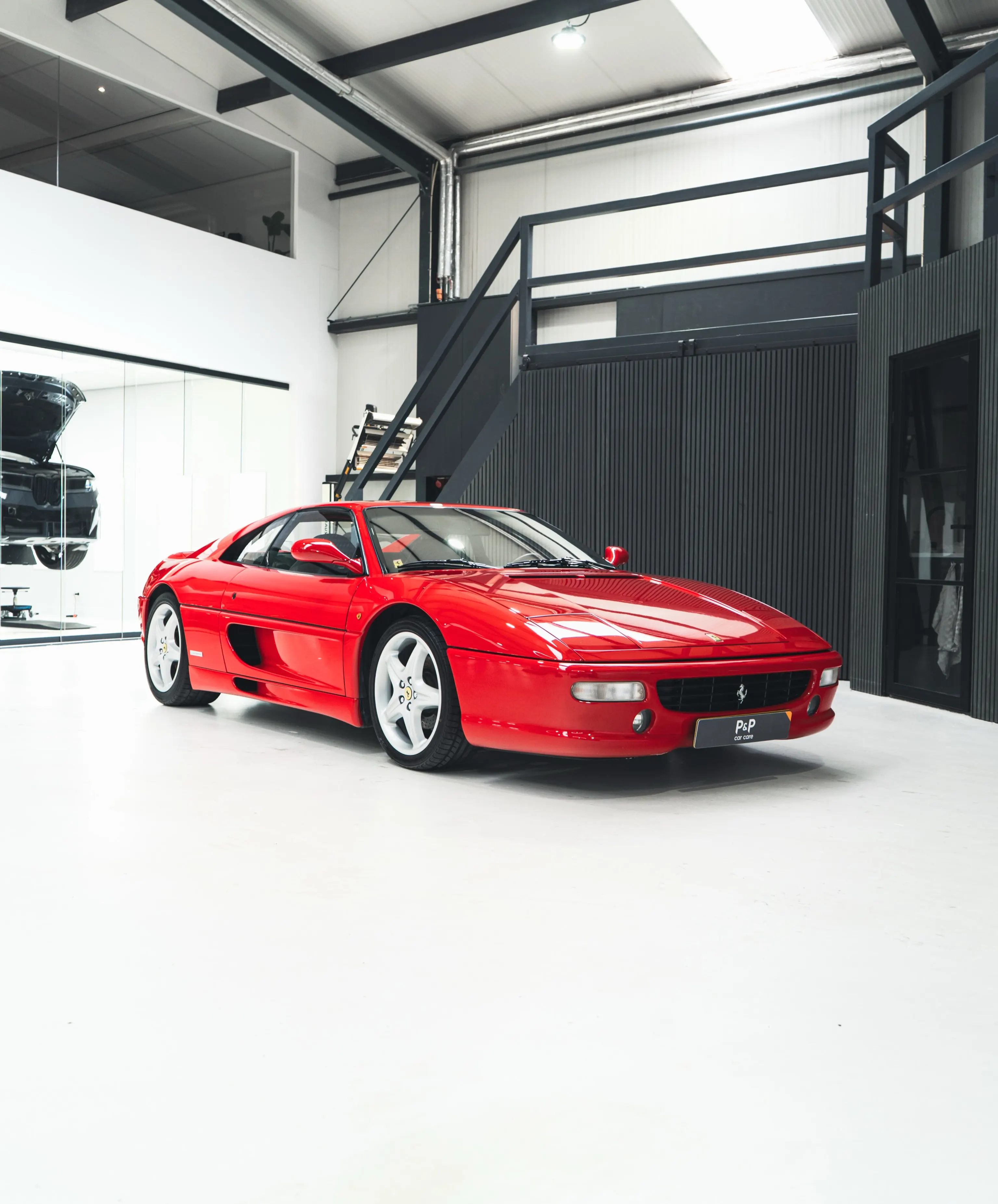 Rode Ferrari F355 GTS in de studio van P&P Car Care, driekwart vooraanzicht