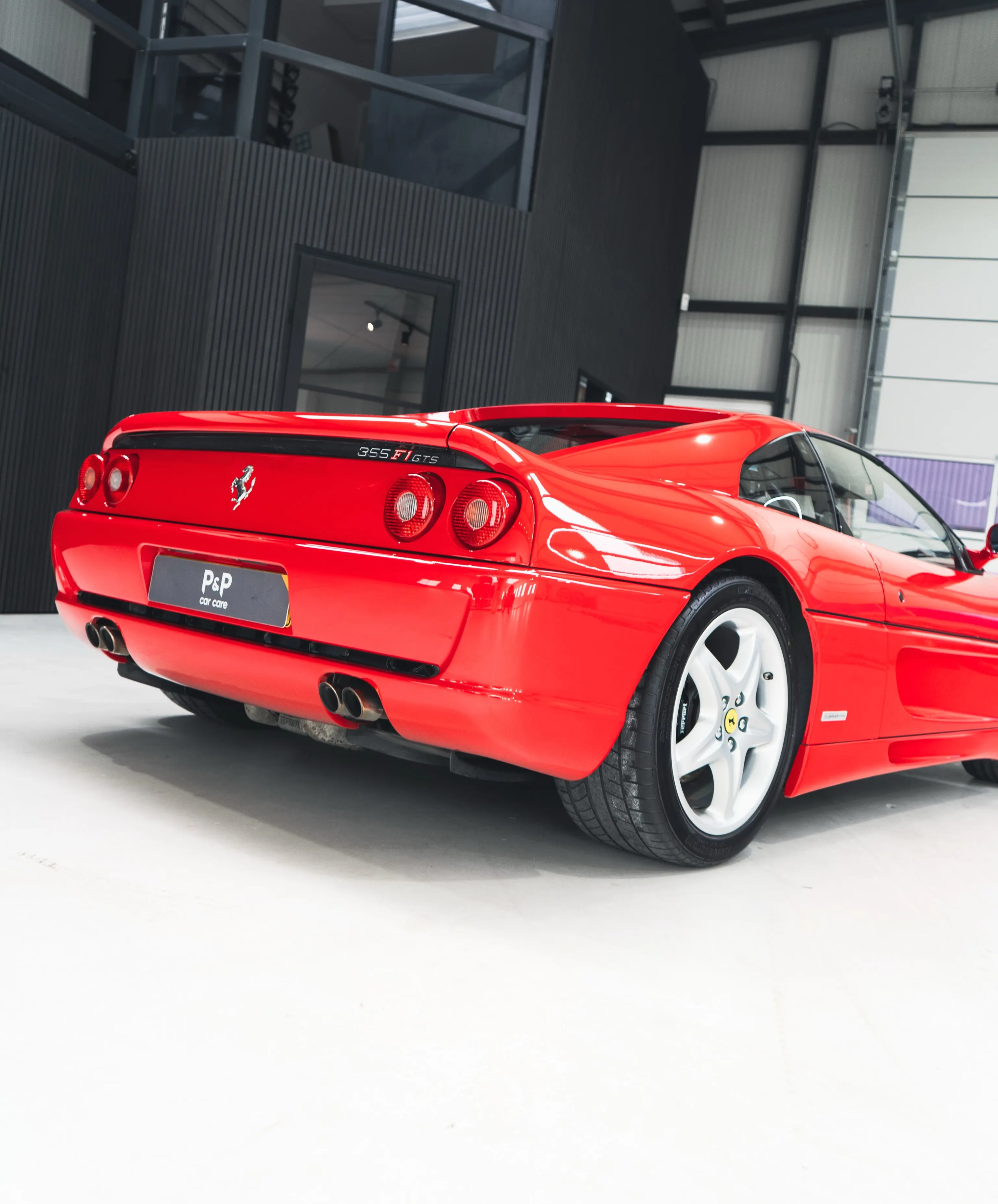Rode Ferrari F355 GTS in driekwart achteraanzicht
