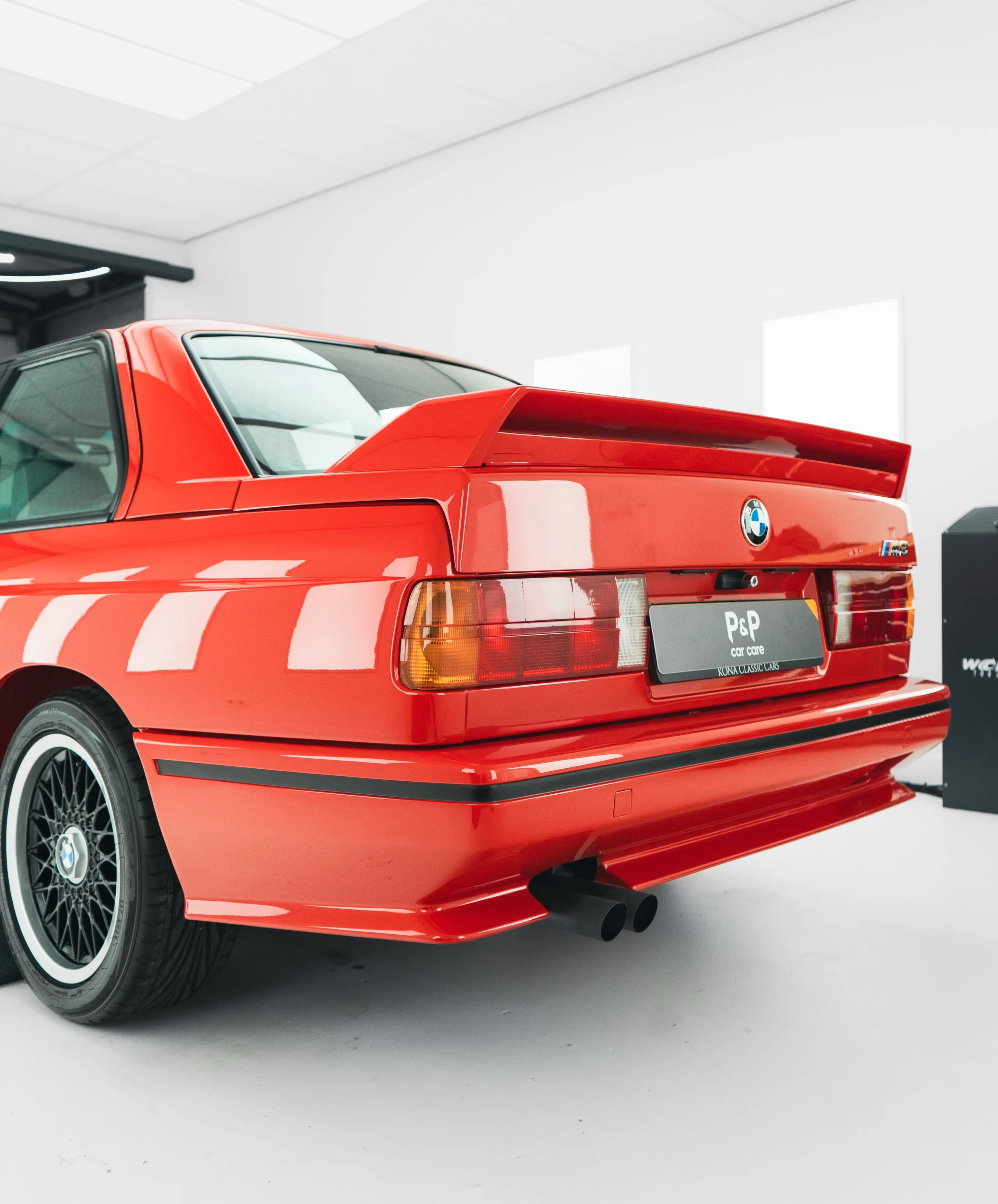 Rode BMW E30 M3 in driekwart achteraanzicht met BBS-velgen