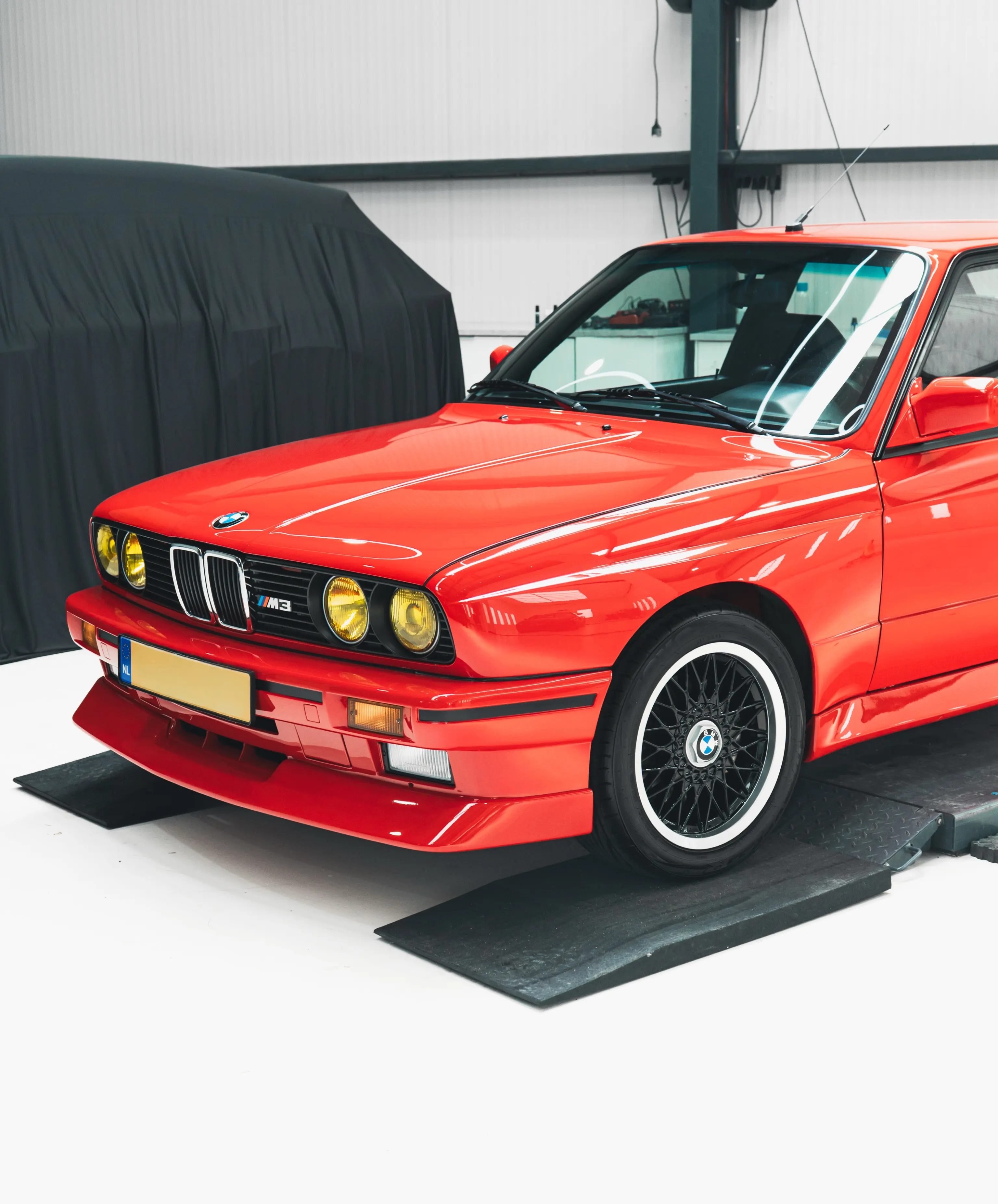 De BMW E30 M3 op de heftafel in de werkplaats