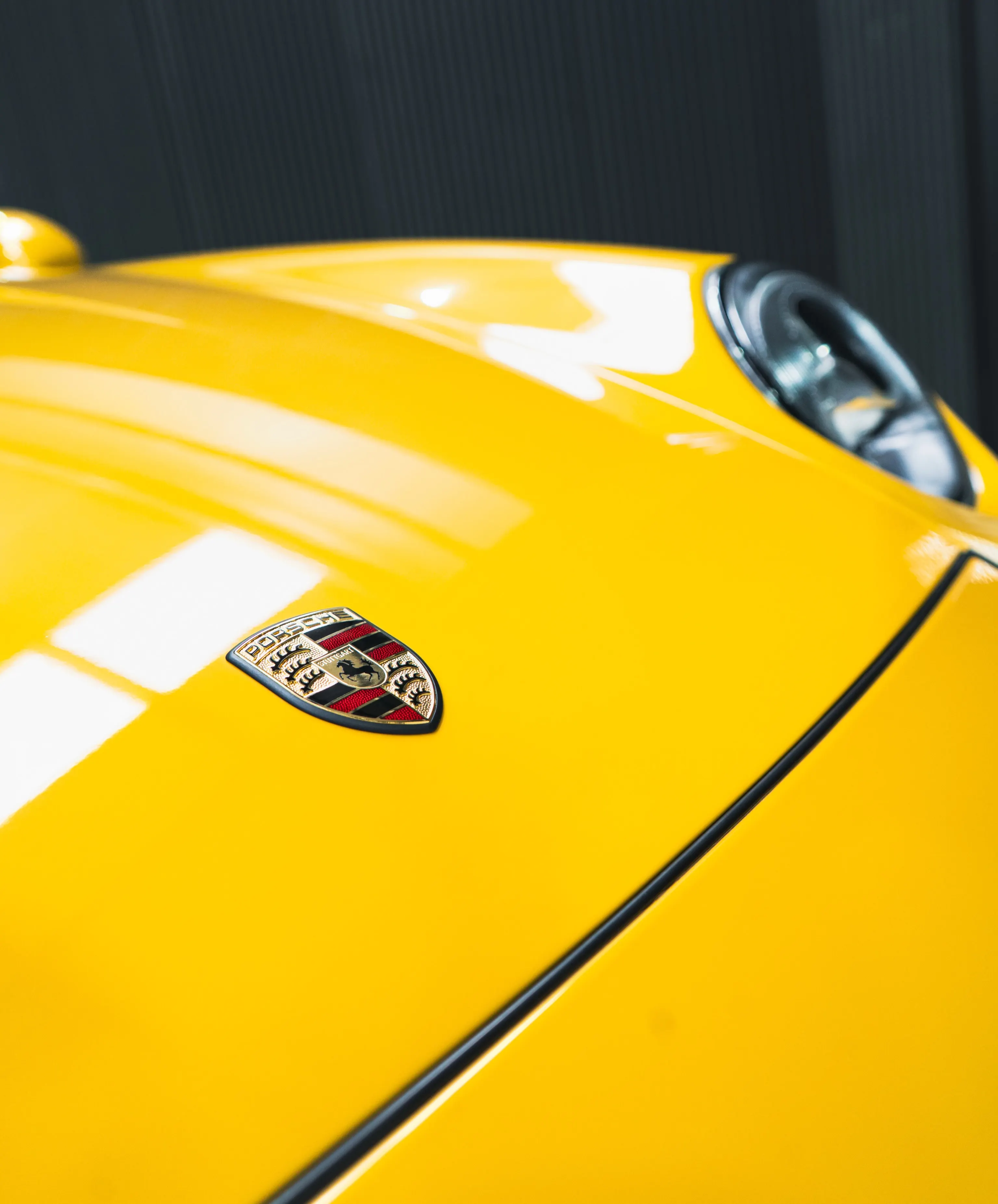Porsche-embleem op de gelakte voorklep van de Porsche 993 Turbo na het coaten