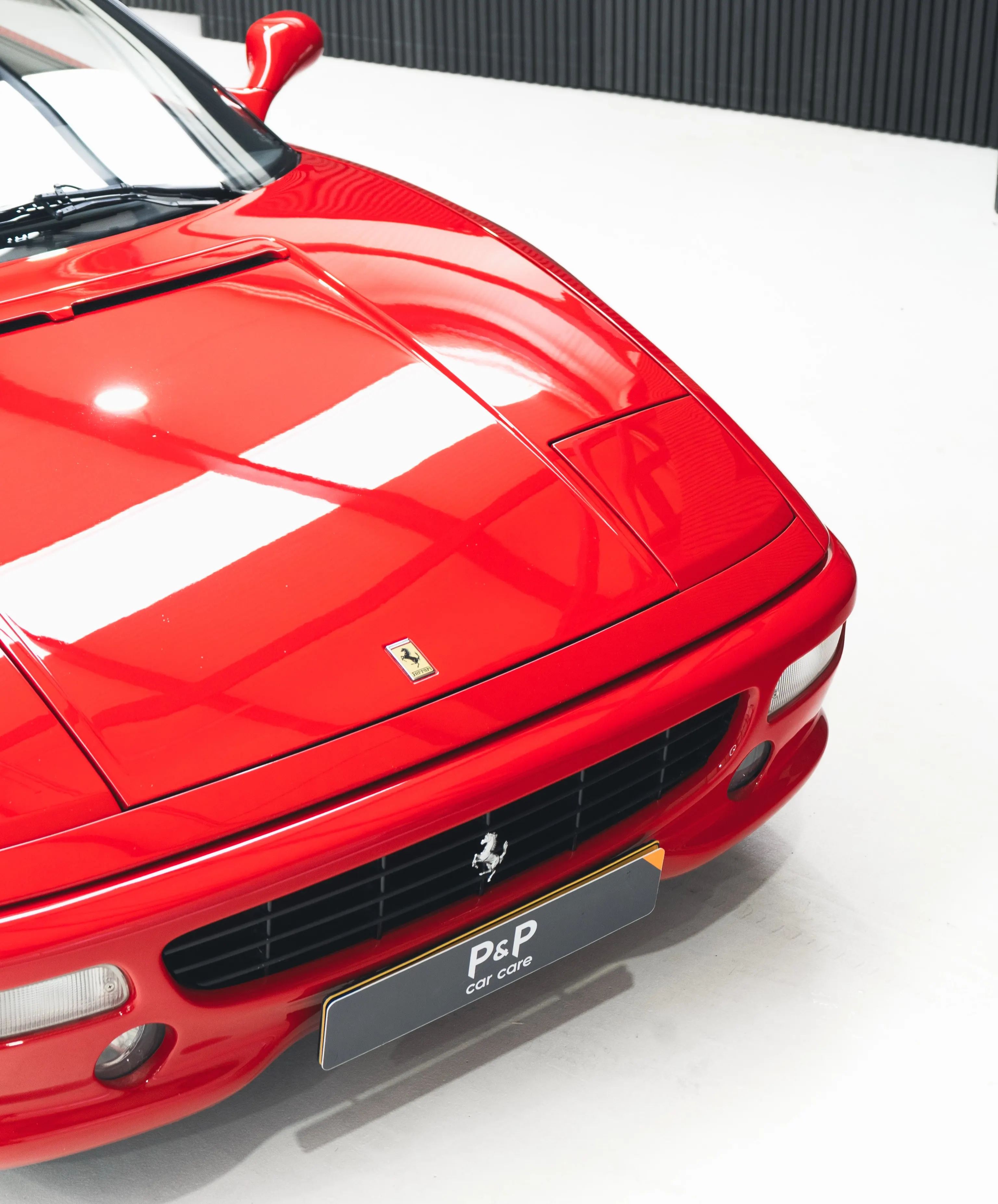 Motorkap en neus van de Ferrari F355 GTS met Ferrari-schild, van bovenaf