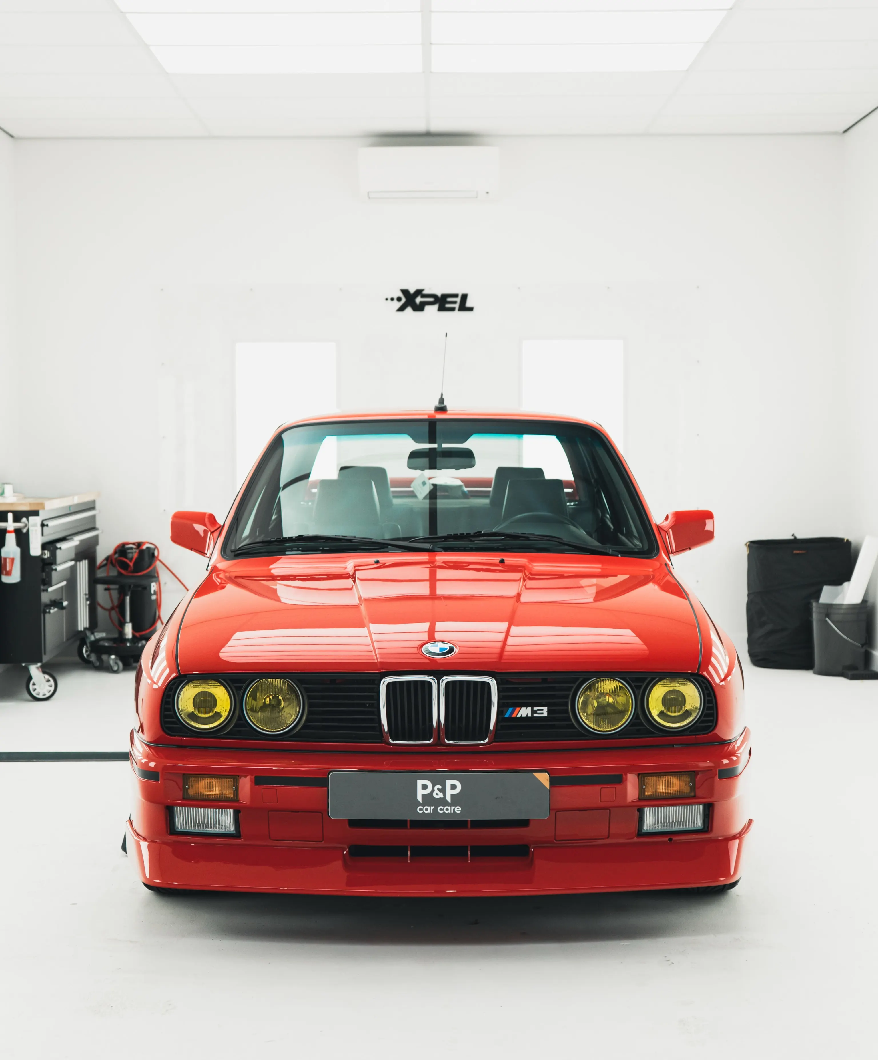 Recht vooraanzicht van de rode BMW E30 M3 in de studio