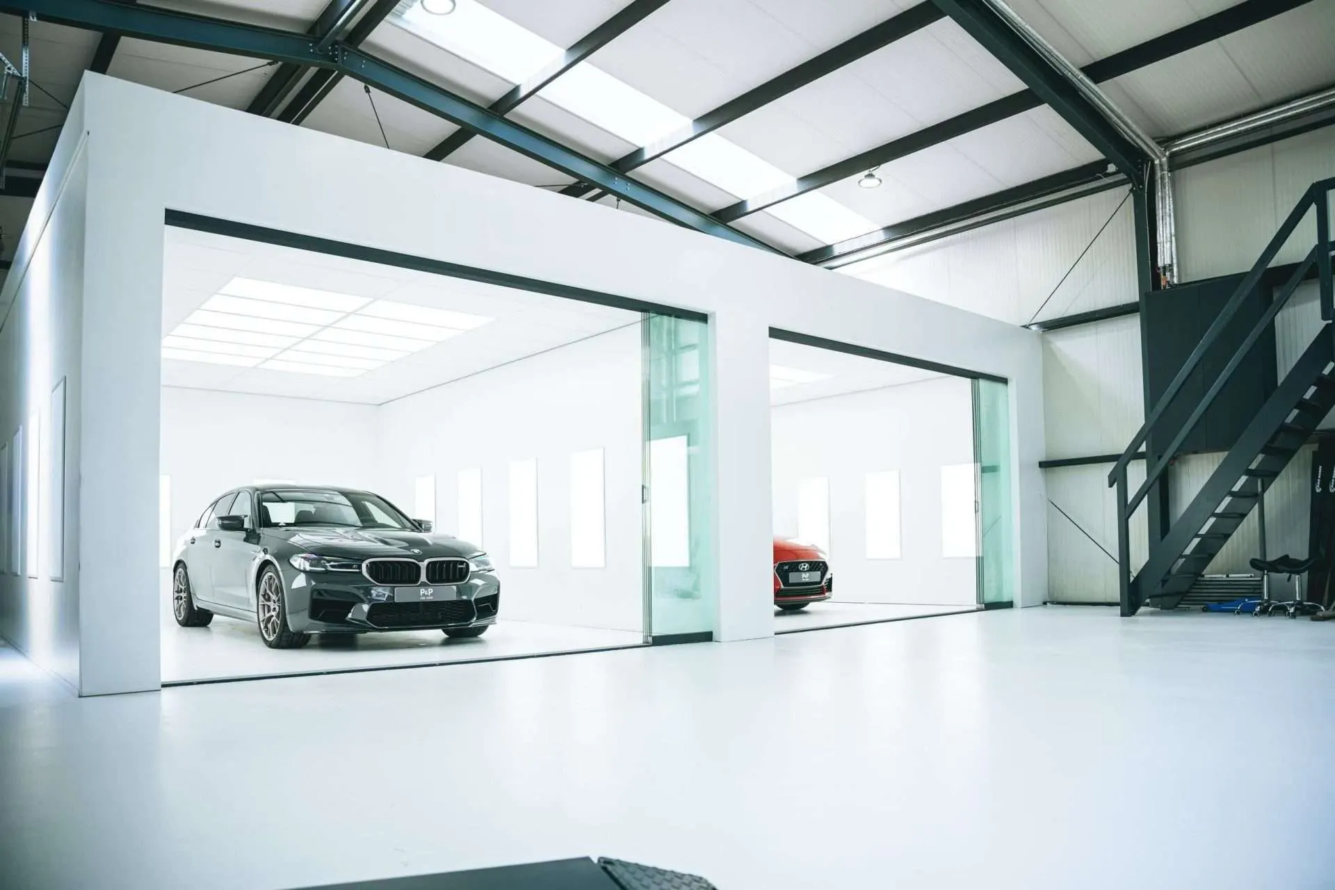 De werkvloer van P&P Car Care met de PPF-cabines op de achtergrond