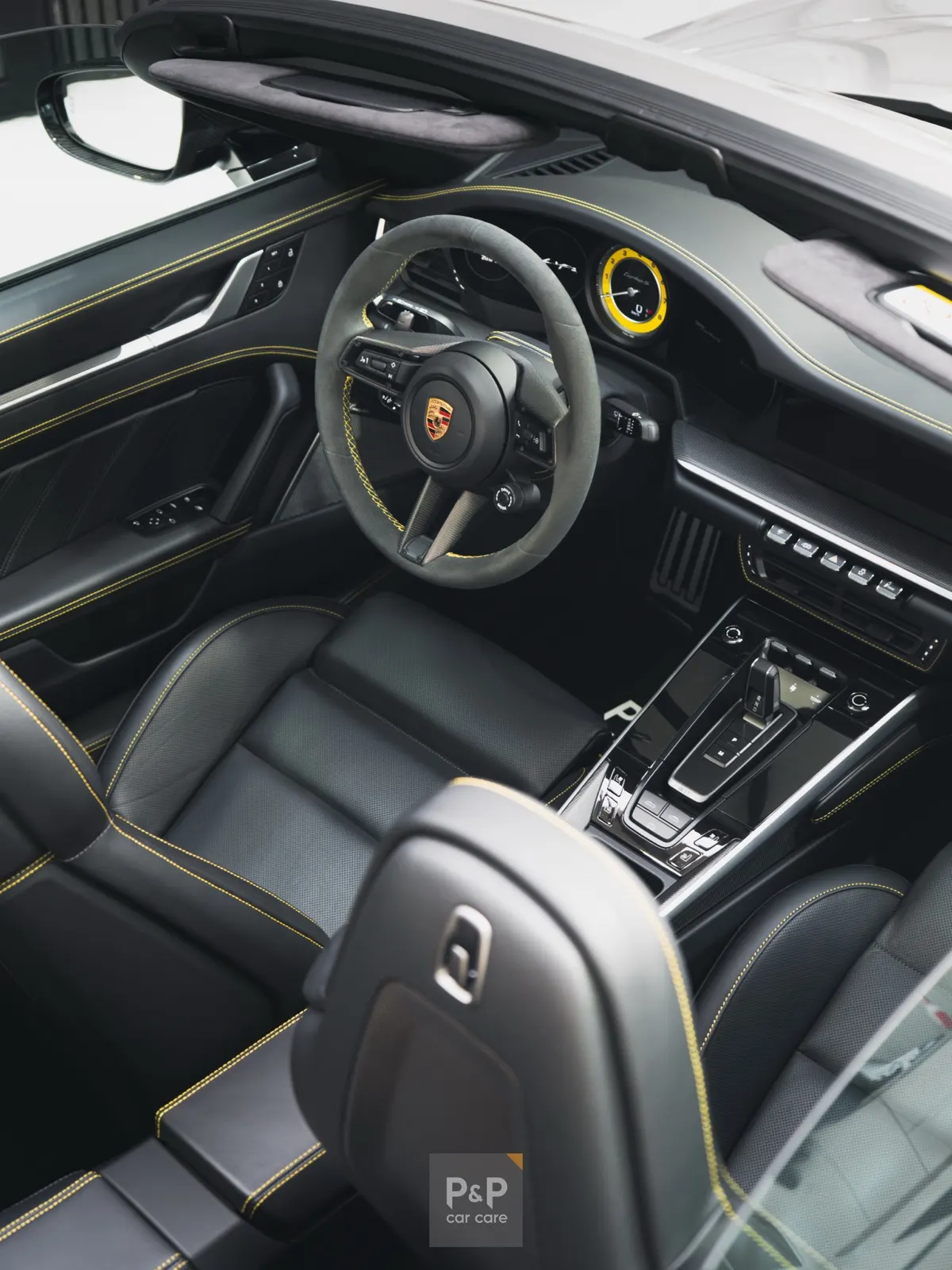 Verzorgd Porsche-interieur met stuur en lederen stoelen