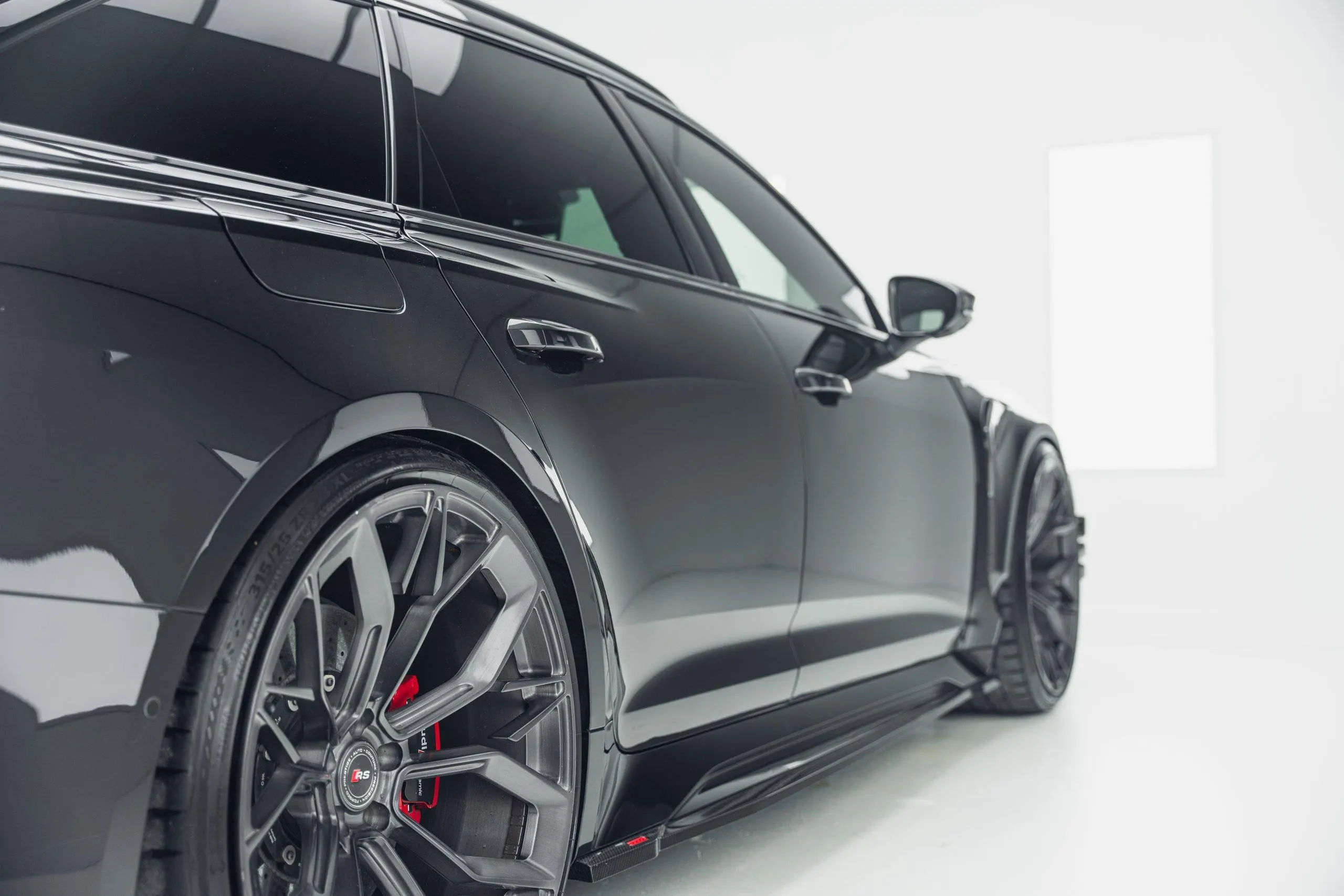 Zijaanzicht van een zwarte Audi RS6 met spiegelgladde lak na lakcorrectie