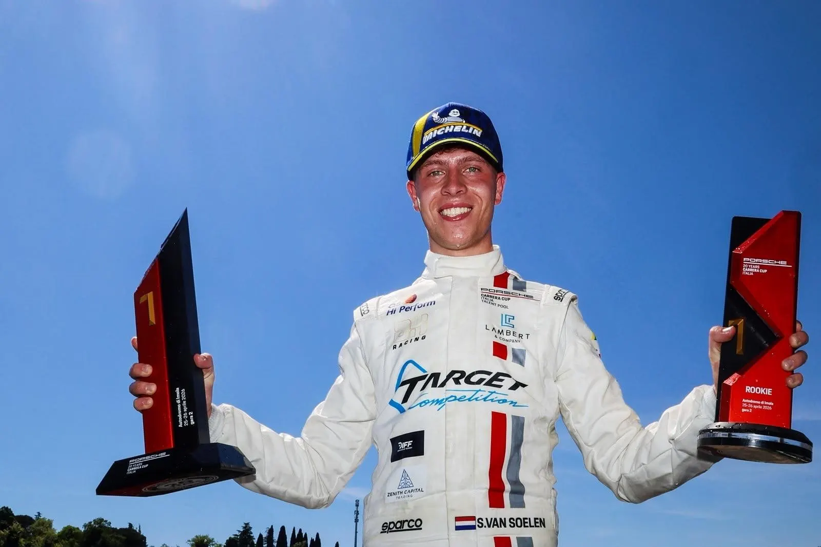 Senna van Soelen in racepak met twee trofeeën na een overwinning