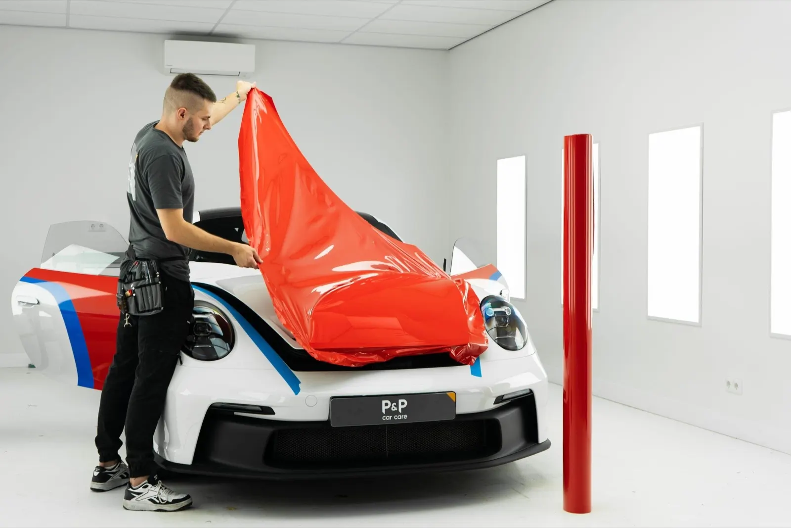 Rode wrapfolie wordt aangebracht op een auto